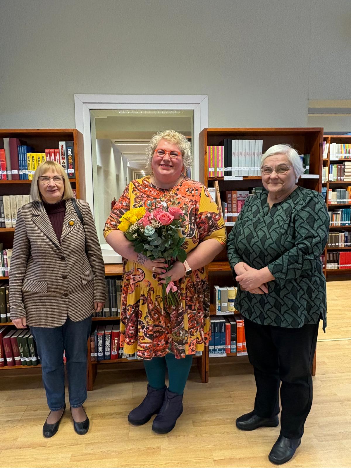 No kreisās: LU HZF profesore Ieva Kalniņa, LU HZF Valodu un kultūru studiju doktorante, stāstu krājuma “četrdesmit burkas gurķu” autore Evija Martukāne Laganovska un LU HZF profesore Lidija Leikuma. Foto: © LU bibliotēka, 2026